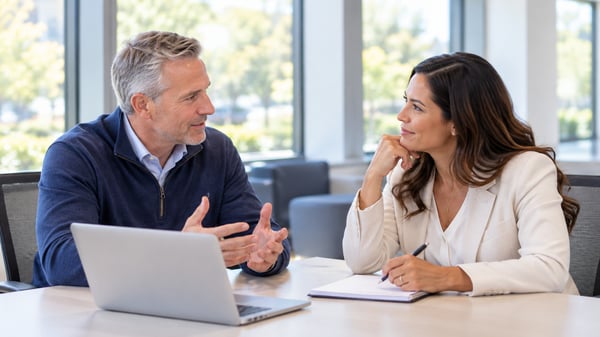 Sales manager and salesperson in a one-on-one coaching conversation reviewing a simple performance chart