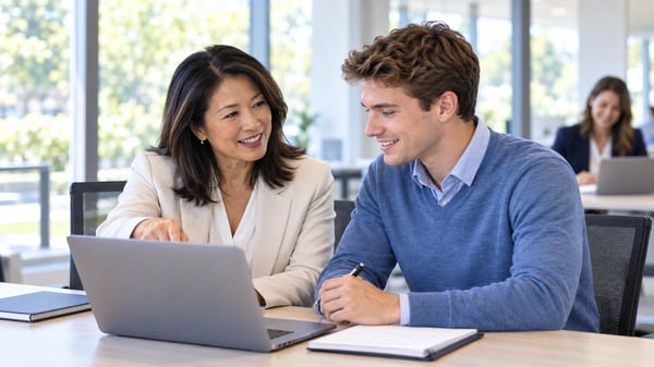 Experienced manager mentoring a new team member in a bright office